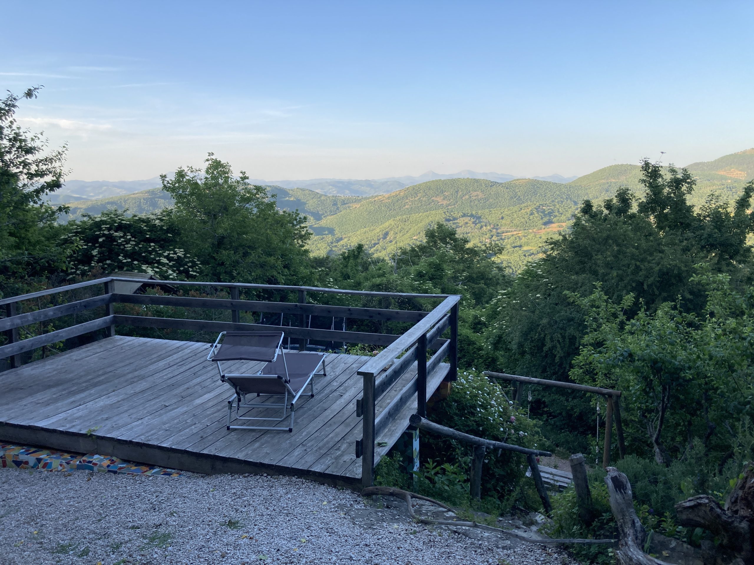 Ausblick über Hügellandschaft in Umbrien, Italien.Holzplattform mit Liegestuhl
