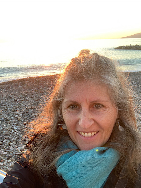 Frau mit Schal im Sonnenschein am Meer