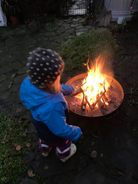 Kleinkind wirft Stock in Feuer