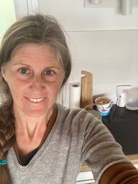 Frau mit grauem Pullover vor sauberer Küche